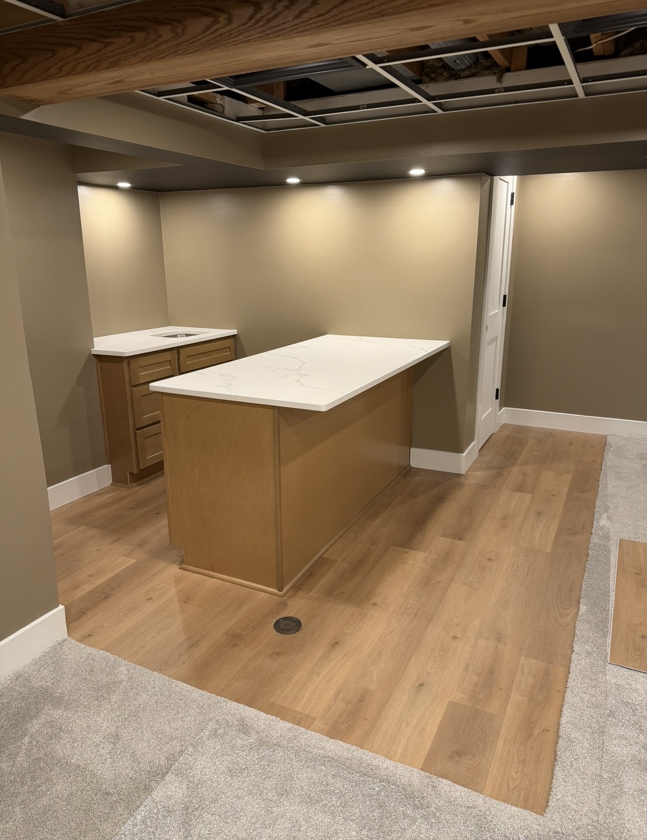 Finished basement living space with quartz-top island and LVP flooring